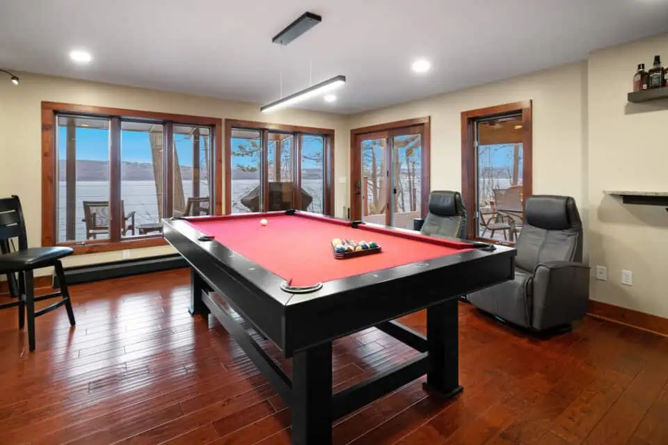 Pool table in finished basement with red felt top